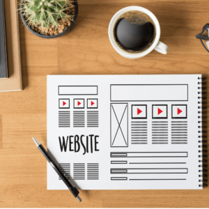 a cup of coffee, pen and a chart written website design